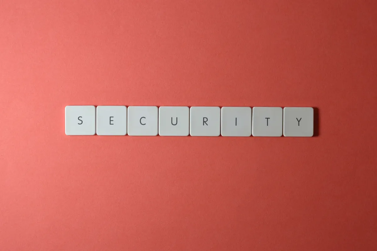 A conceptual image of the word 'security' spelled with keyboard keys on a red surface, providing copy space.